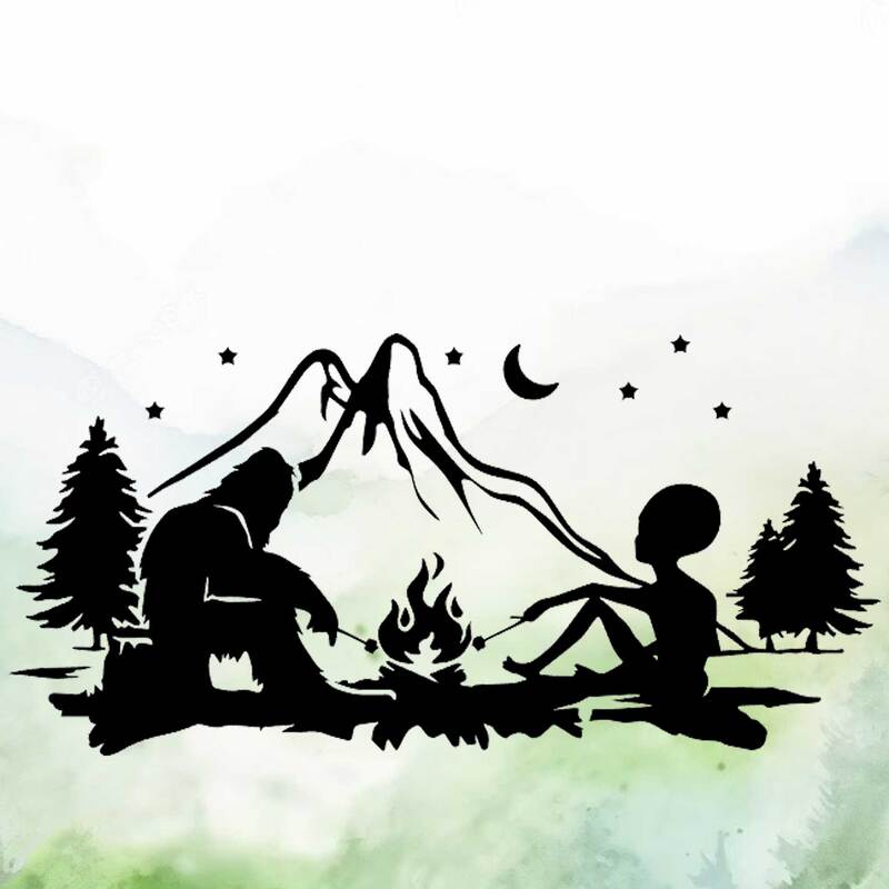 Silhouette of bigfoot and alien roasting marshmallows over a campfire with mountains and night sky in the background.