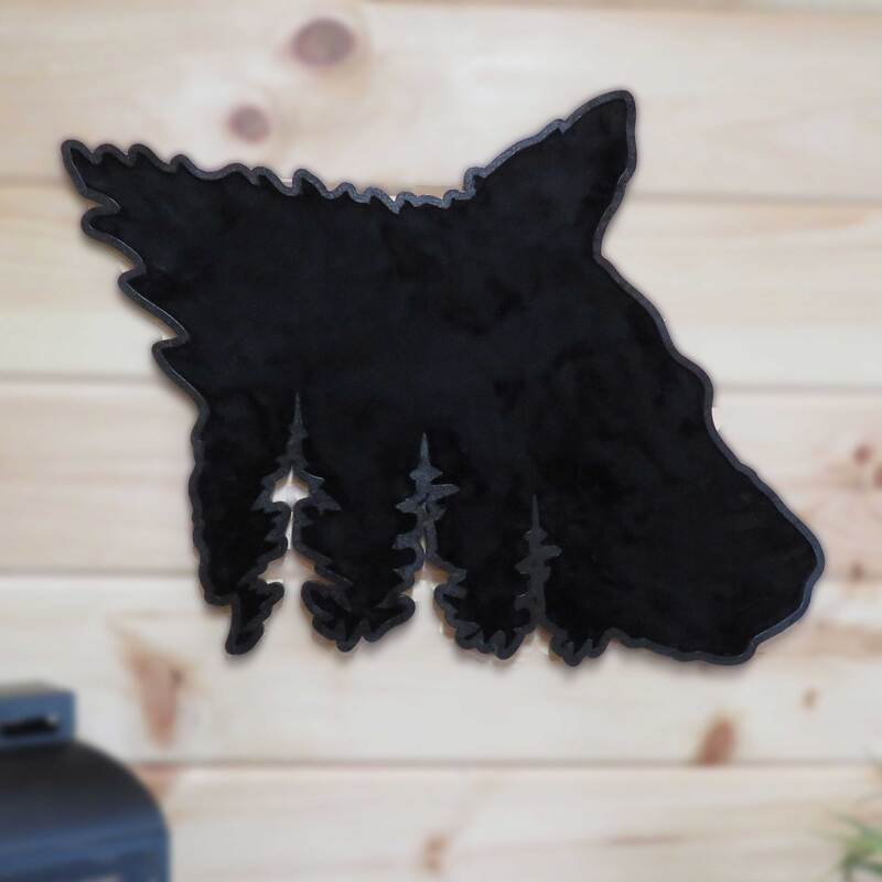 Wood black bear head with tree silhouette cutouts painted black with faux fur insert and hung on pine wall.