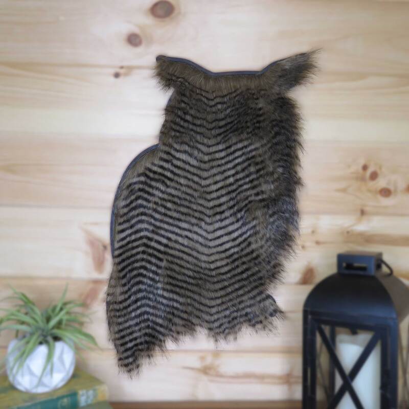 Wood owl with faux fur insert and hung on pine wall.